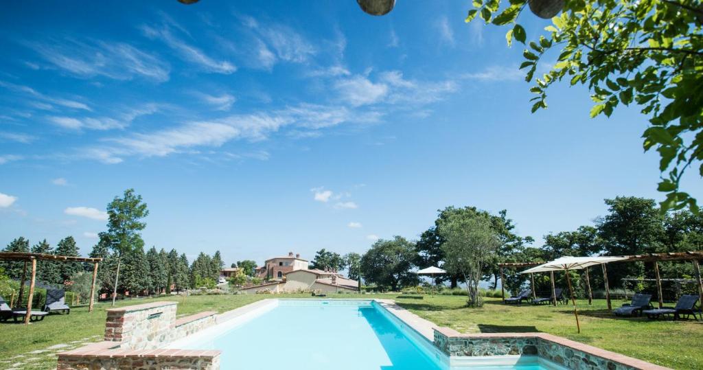einen Pool auf einem Feld mit blauem Himmel in der Unterkunft Cignella Resort in Trequanda