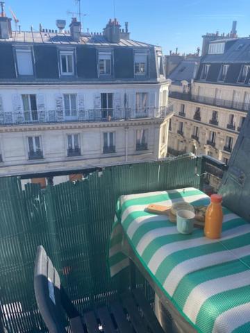 a table on a balcony with a view of a building at Studio Quartier Latin in Paris