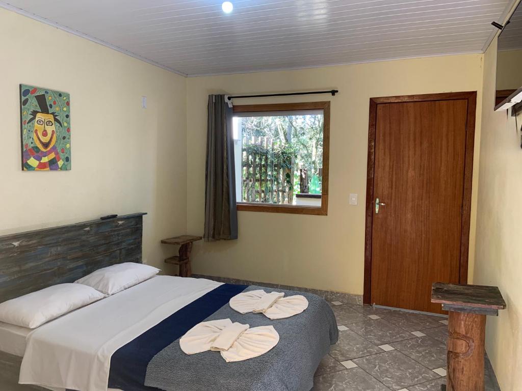 um quarto com uma cama com duas toalhas em Pousada Casinha Velha em Macacos