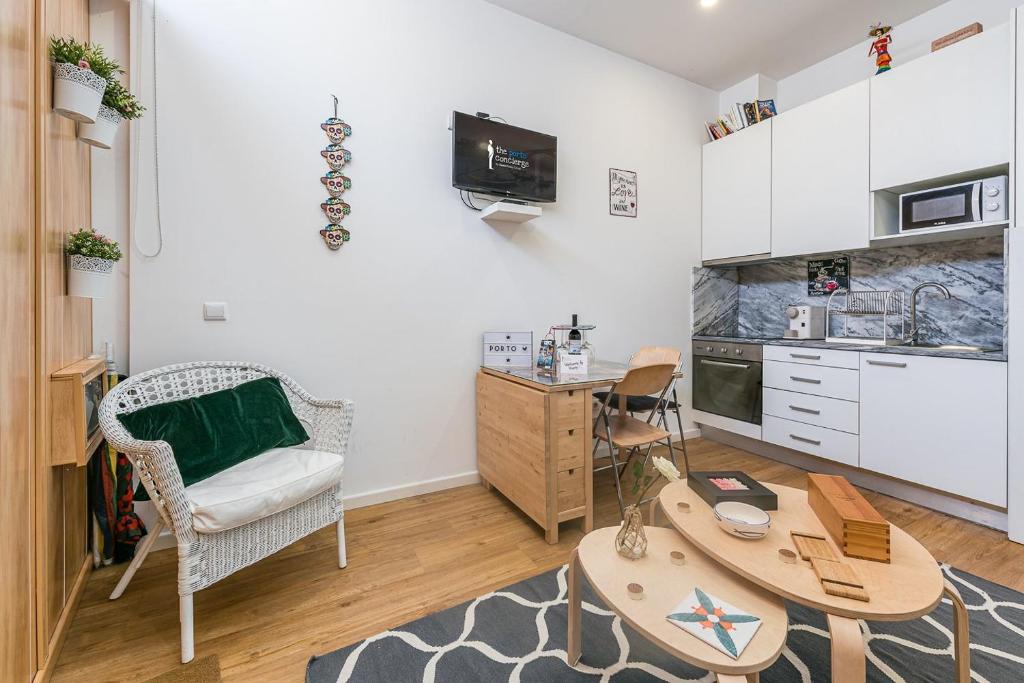 a living room with a table and a kitchen at GuestReady - Bella's Downtown Apartment in Porto