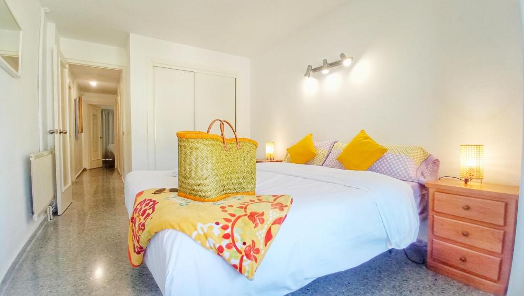 ein Schlafzimmer mit einem Bett und einem Korb darauf in der Unterkunft Fantastico Duplex Familiar Dunas Artola in Marbella