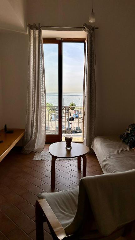 a living room with a table and a large window at Beautiful and Cozy Seaview Residence in Pozzuoli