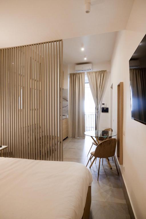 a bedroom with a bed and a desk and a table at ADOUNIA HOME in Naples
