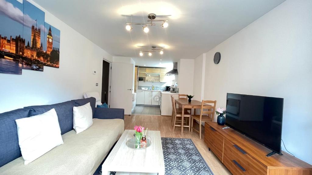 ein Wohnzimmer mit einem Sofa und einem Flachbild-TV in der Unterkunft Shoreditch Liverpool Street Apartments with lift and balcony in London