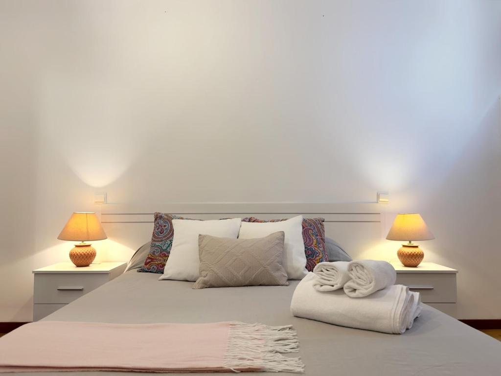 een bed met twee lampen en twee handdoeken erop bij El Cobijo de Somo - 30803 in Somo