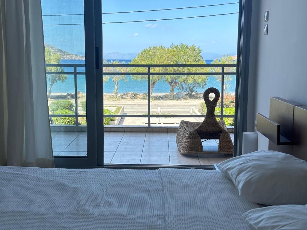 um quarto com uma cama e vista para o oceano em Seashore Happiness Apartments em Porto Rafti