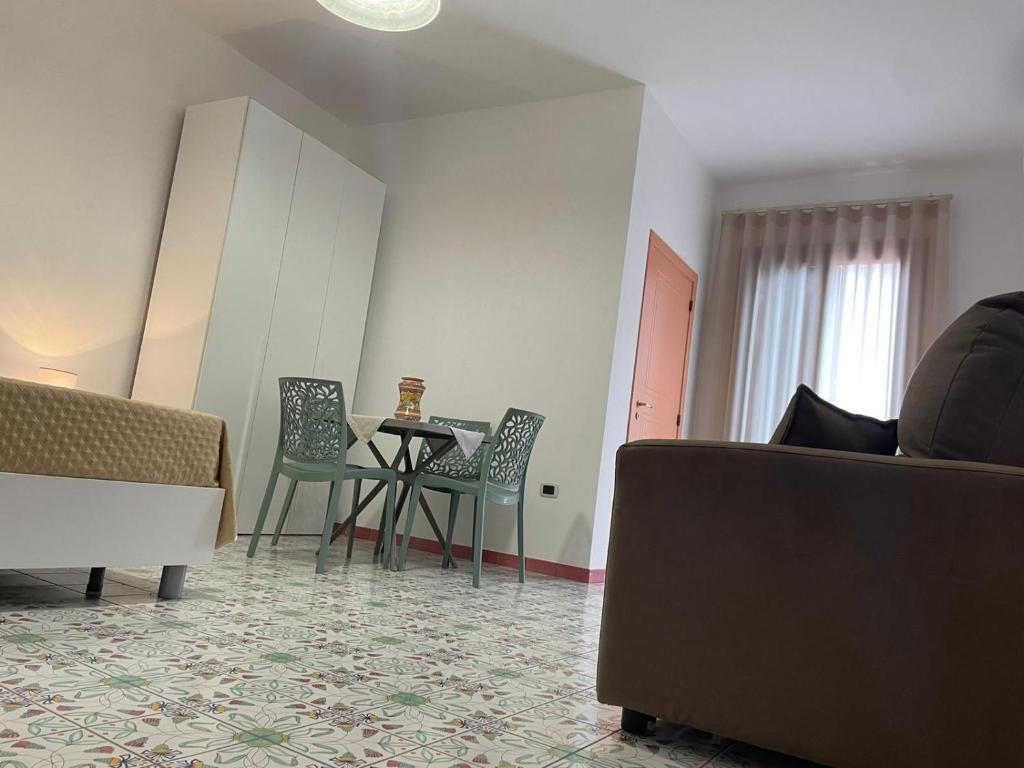 een woonkamer met een tafel en stoelen bij Cairoli Apartments in Licata