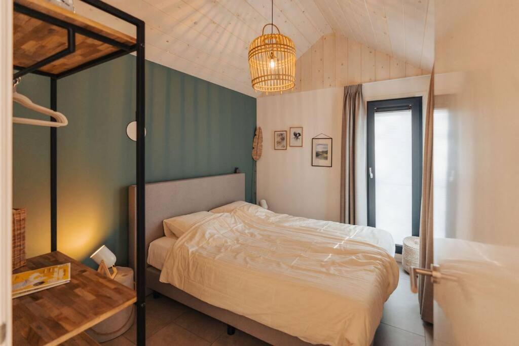 una camera con letto e lampadario a braccio di Kos I Tiny house met grote tuin a Epe