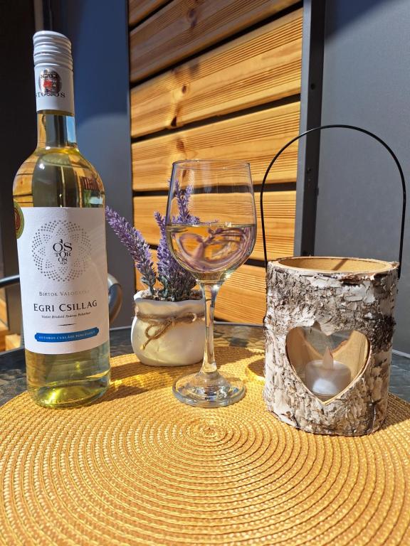 a bottle of wine and a glass on a table at Várfal apartman II in Eger