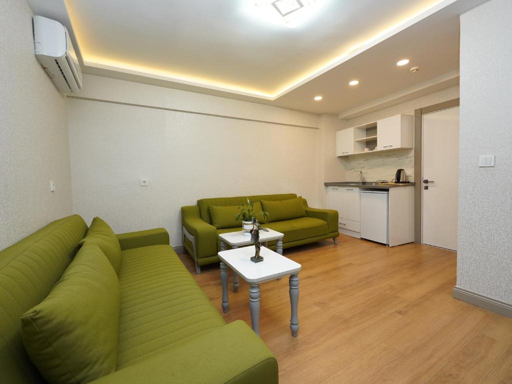 a living room with two green couches and a table at gazelle suites in Istanbul