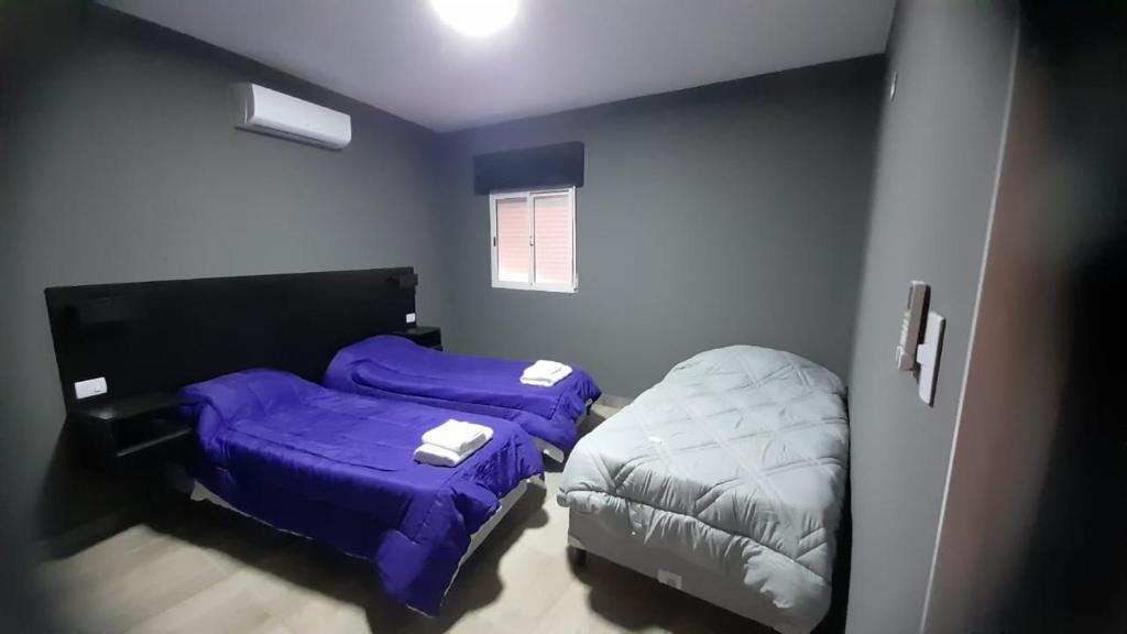 duas camas num quarto com lençóis roxos em Arena blanca em Fiambalá