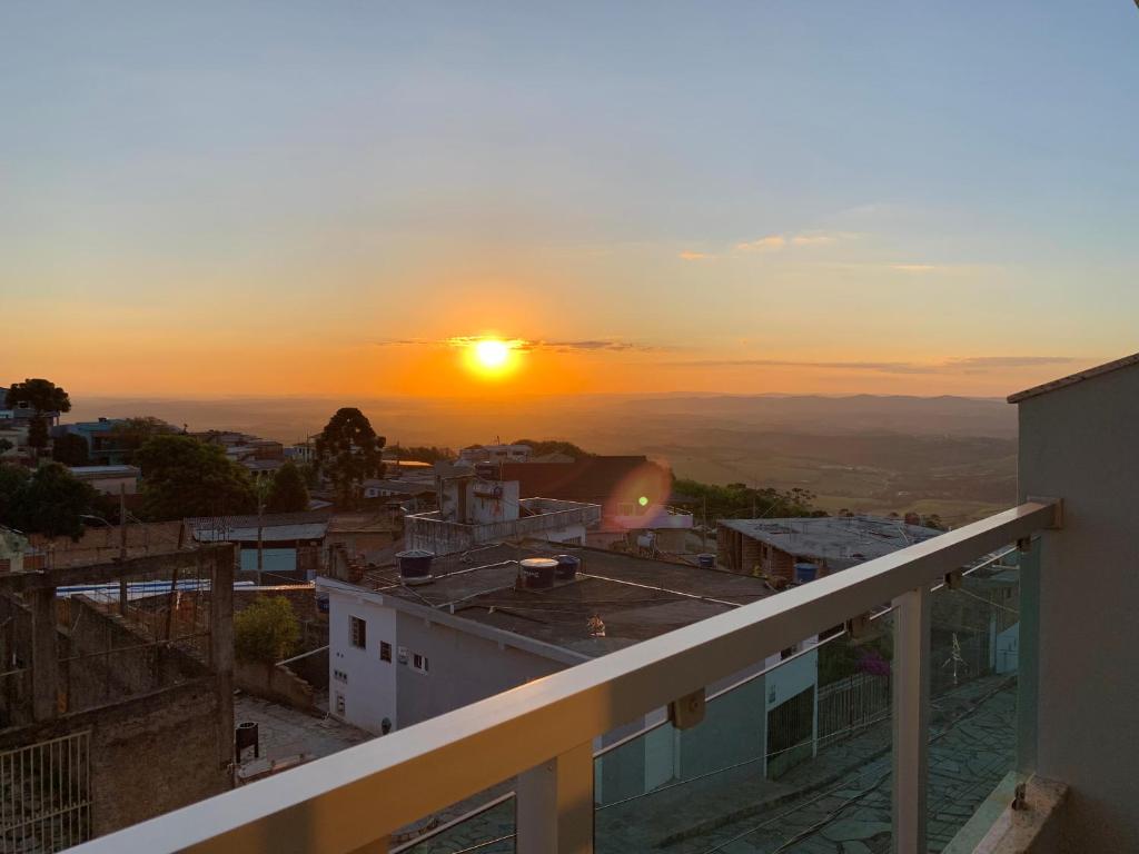 a view of the sunset from the balcony of a building at Pousada Aconchego De São Thomé in São Thomé das Letras