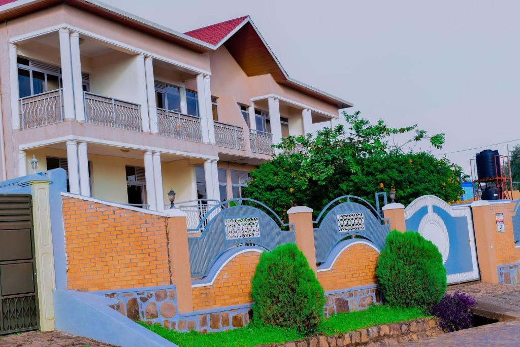 uma casa com uma cerca em frente em Green V Apartments em Kigali