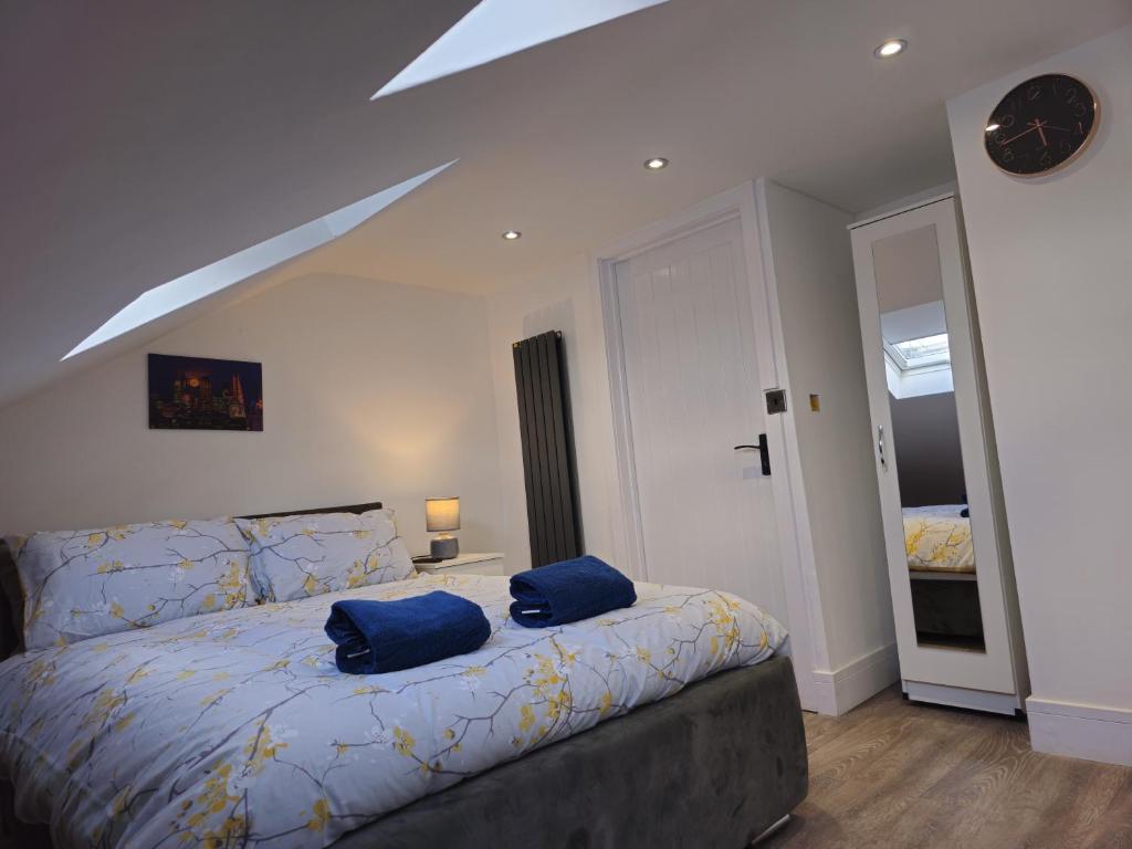 una camera da letto con un letto con due cuscini blu sopra di Forest Edge Inn a Londra