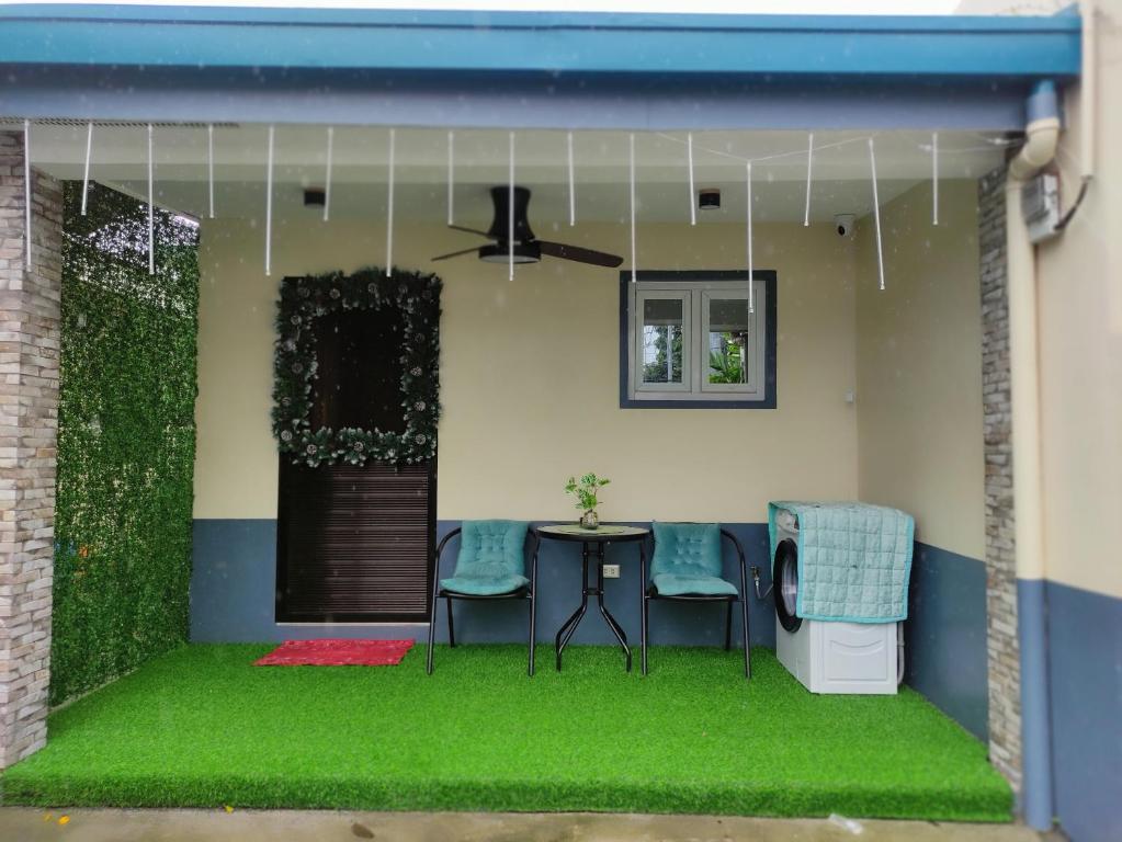 a patio with green grass and a table and chairs at Casita de Reina Staycation House - A cozy 1-Bedroom condo-style house in Locsin