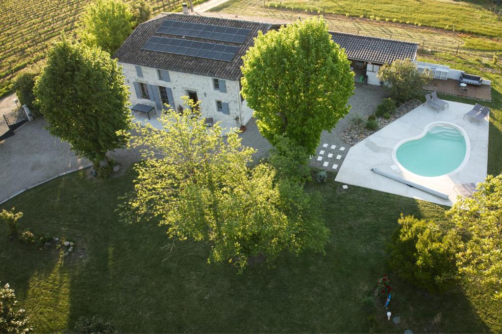 Cette chambre offre une vue sur une maison dotée d'une piscine et d'arbres. dans l'établissement Le Nid du Coucou, à Cocumont