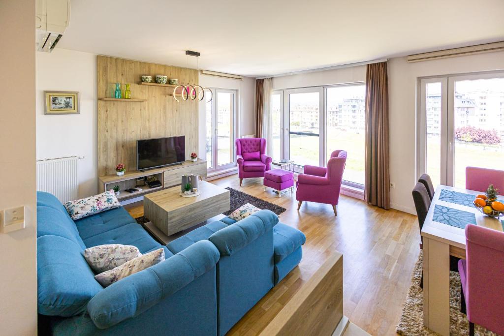 a living room with a blue couch and purple chairs at Ilidza River Apartments in Sarajevo