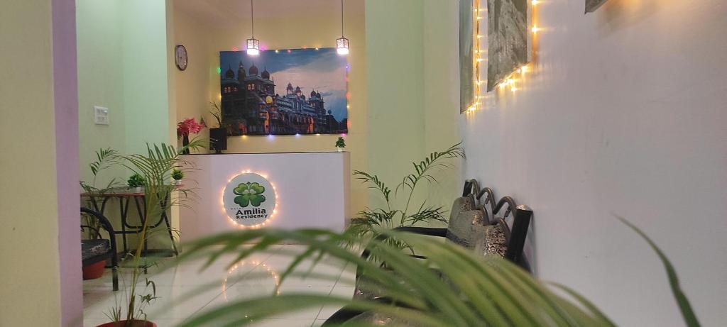 una stanza con piante e una foto di un castello di ADH Amilia Residency a Mysore