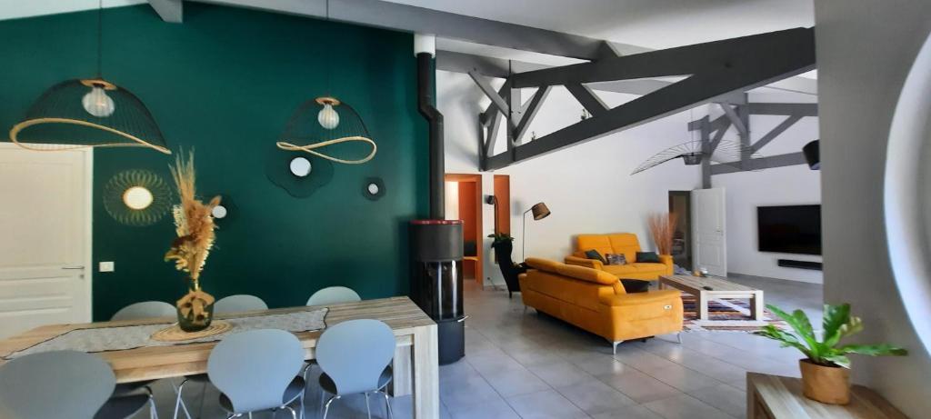 un salon avec une table et un canapé jaune dans l'établissement Villa piscine chauffée dans un écrin de verdure, à Biscarrosse