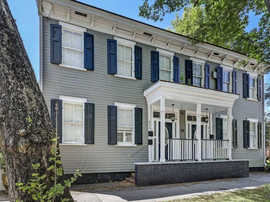 Une grande maison avec volets bleus dans l'établissement Historic Savannah Gold Private Condo with Pool - 2bed, 1&half bath, Sleeps 6, 1st Floor, 15 Min Walk To Historic Savannah Center And All Attractions, à Savannah