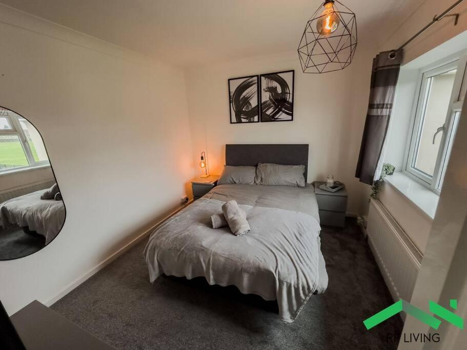 ein Schlafzimmer mit einem Bett mit einem Kissen darauf in der Unterkunft Lovely Bedroom in Modern House in Cleethorpes