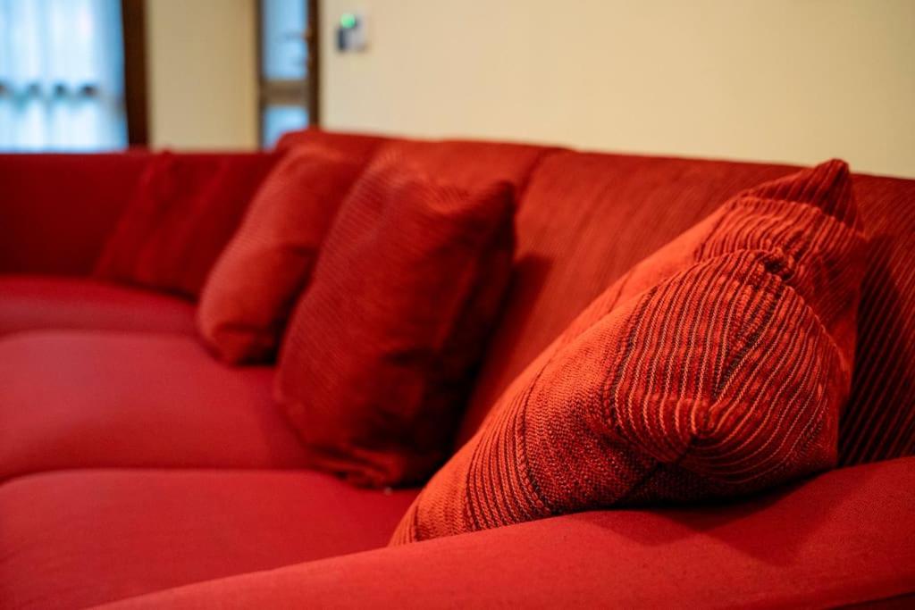 eine rote Couch mit roten Kissen drauf in der Unterkunft Milo Apartments - Hydro-massage - Sassuolo - Maranello in Casalgrande