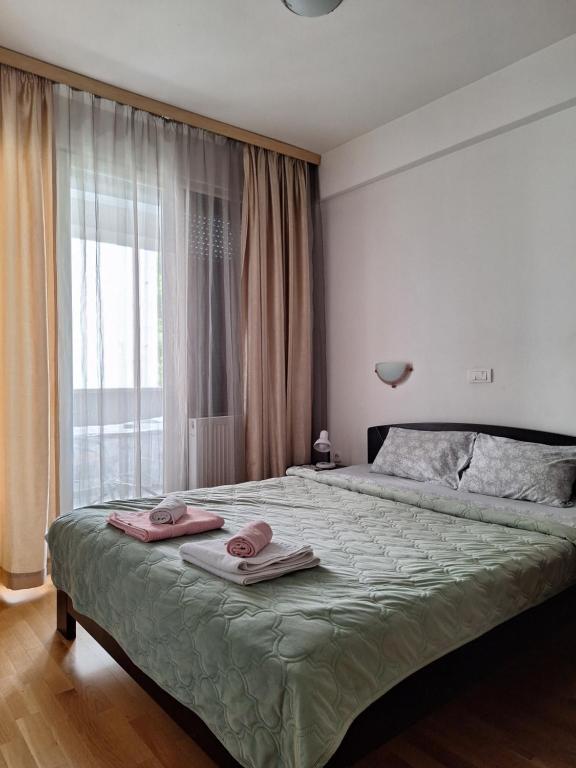 a bedroom with a large bed with two towels on it at Metropolis Skopje Apartments in Skopje