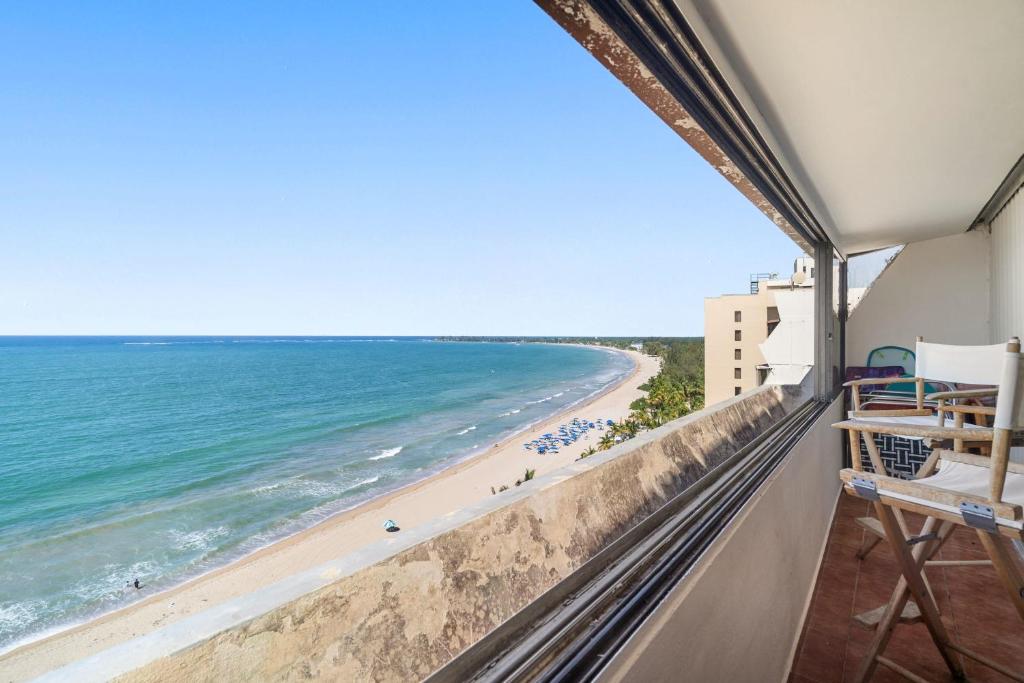 a view of the beach from the balcony of a condo at Oceanfront Paradise - Spacious and Family Friendly in San Juan