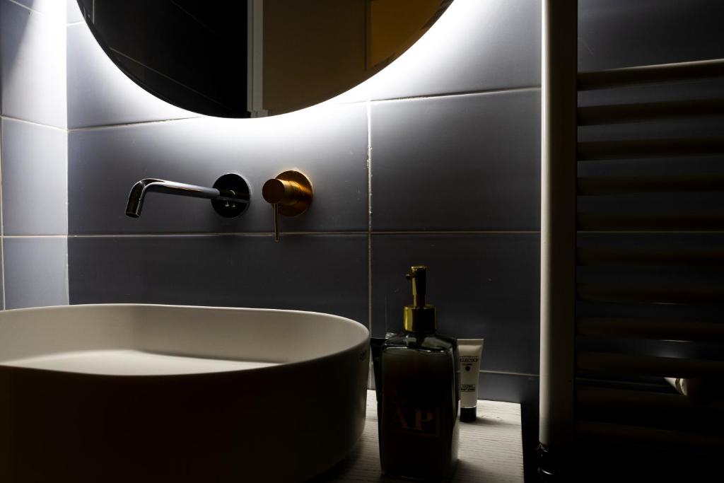 a bathroom with a tub and a round mirror at Ginevra Boutique Rooms - Palazzo Leosini - Residenze D'Epoca in LʼAquila