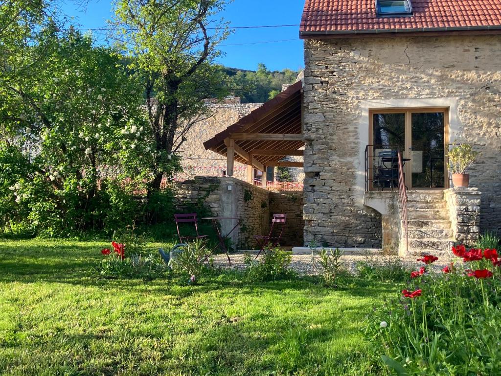 een stenen huis met een tuin met bloemen bij La Petite Maison in Auxey-Duresses