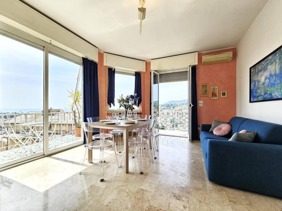 uma sala de estar com um sofá azul e uma mesa em Parking,WiFi, Netflix - Sunny Sea View Haven em Rapallo