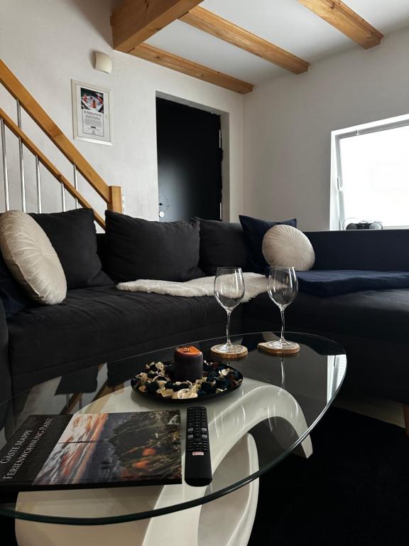 a living room with a black couch and a glass table at Wohnung im Herzen von Immenstadt im Allgäu in Immenstadt im Allgäu