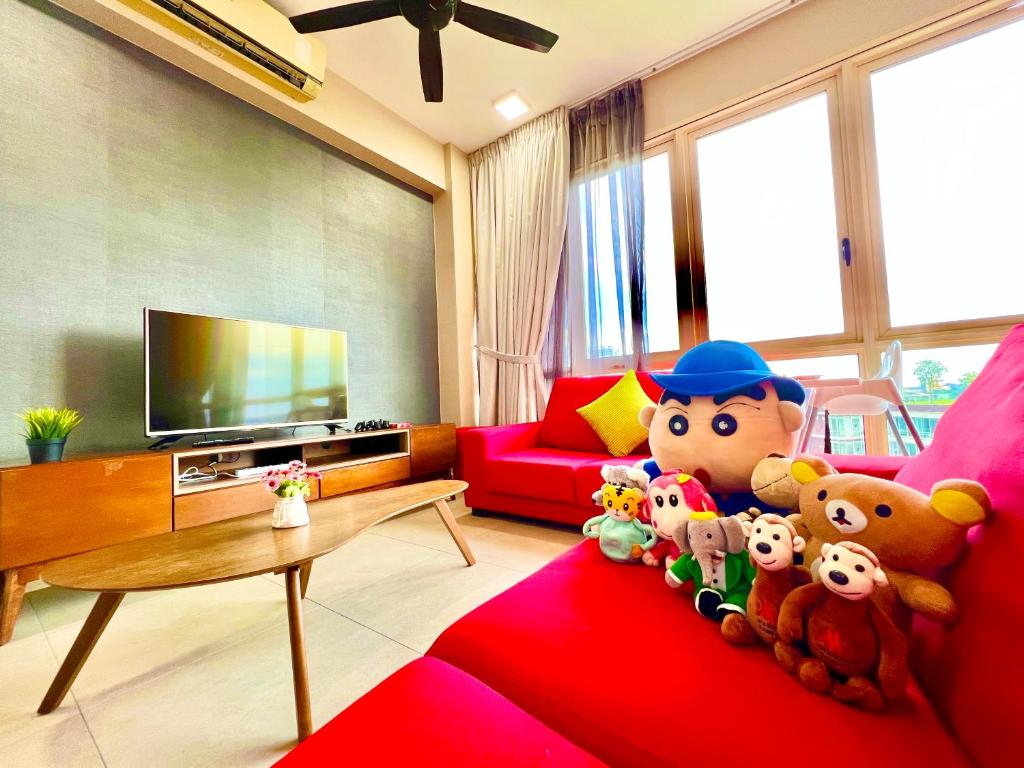 un soggiorno con animali di peluche su un divano rosso di Legoland-3min Walk-HappyDream Suite at Afiniti -8pax-Cozy,Comfy&Convenience 2BR with Bathub a Nusajaya