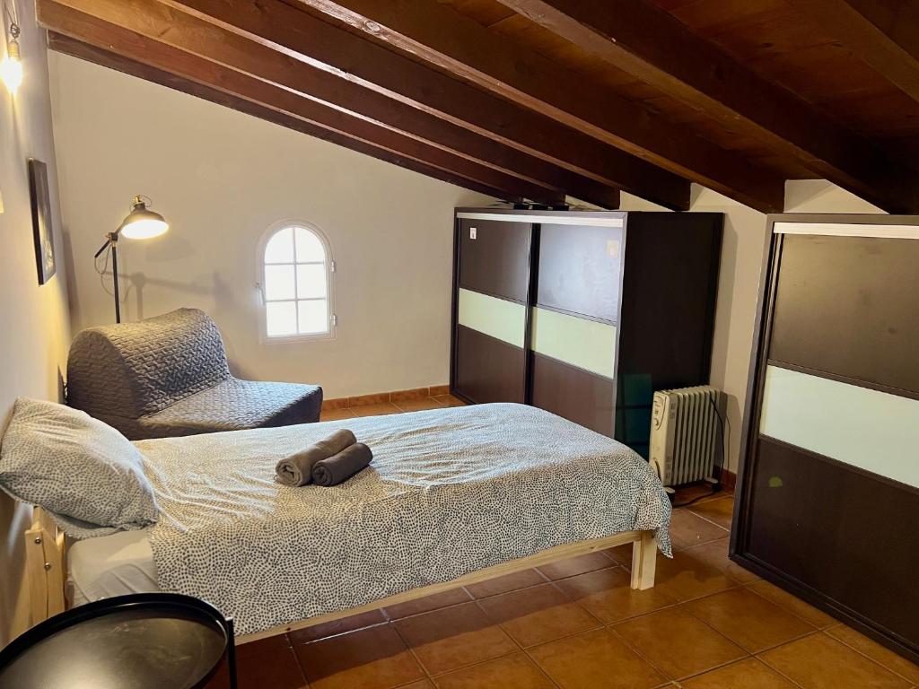 - une chambre avec un lit et une chaise dans l'établissement La Terraza de Consolación 17, à Cáceres