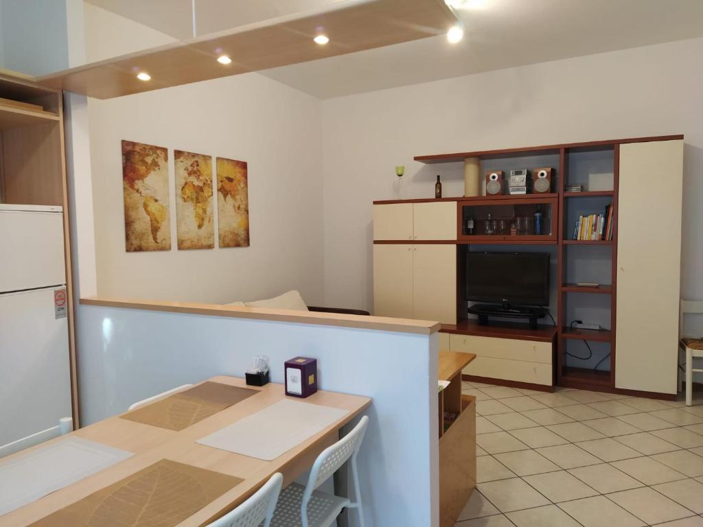 a kitchen with a counter and a table and a tv at Appartamento 2 camere in Imola