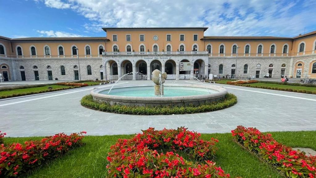 a large building with a fountain in a courtyard at CAPOSTAZIONE22 in Pisa