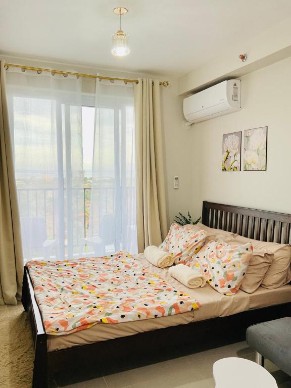 a large bed in a bedroom with a window at Condo near Airport in Lapu Lapu City