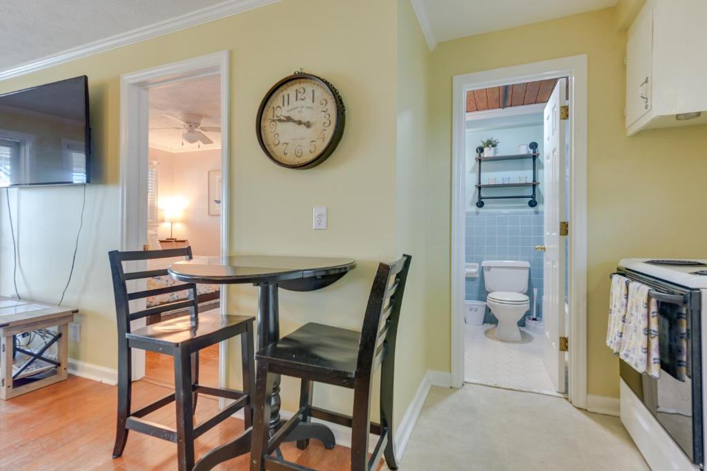 eine Küche mit einem Tisch, 2 Stühlen und einer Uhr an der Wand in der Unterkunft Steps to Ocean North Myrtle Beach Condo with Porch! in Myrtle Beach