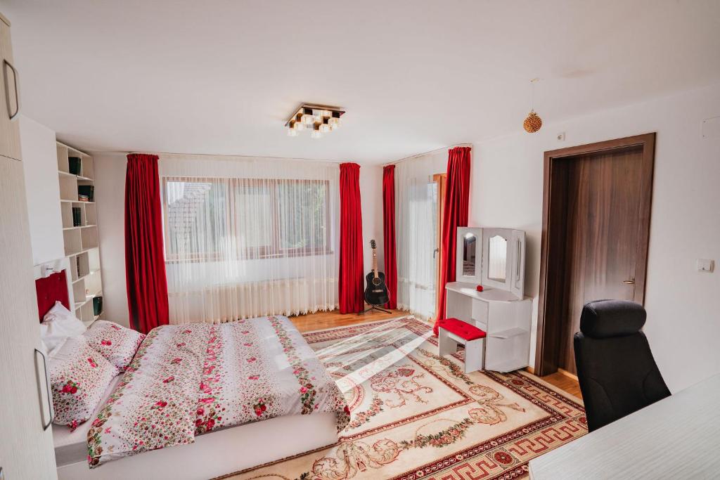 - une chambre avec des rideaux rouges, un lit et une télévision dans l'établissement Diana Resort, à Timişoara