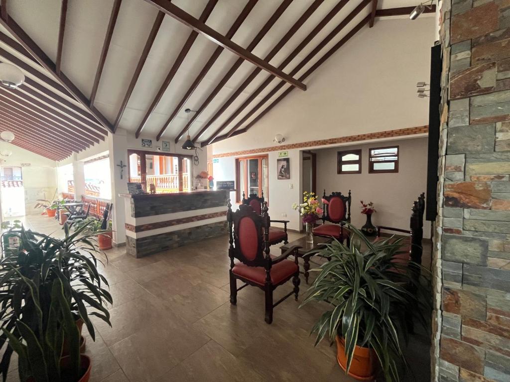 eine Lobby mit Stühlen und Pflanzen in einem Gebäude in der Unterkunft Casa Lewana in Villa de Leyva