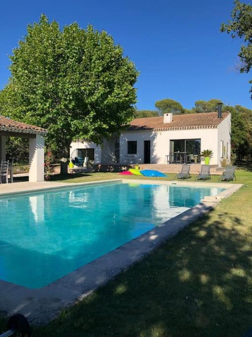 une grande piscine bleue devant une maison dans l'établissement Proche Aix-en-Provence maison avec piscine - 10 personnes, à Rognes