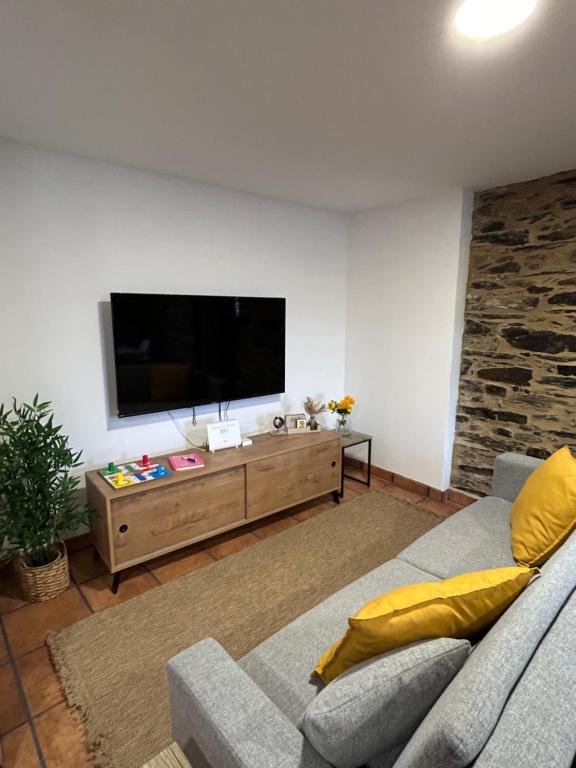 ein Wohnzimmer mit einem Sofa und einem Flachbild-TV in der Unterkunft A Barreira in Ferrol