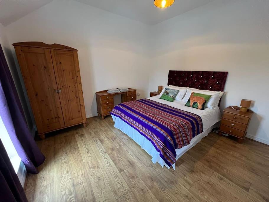 a bedroom with a bed and two night stands at Alpaca farm 3 bed farmhouse THE ALPACA PLACE in Dromara
