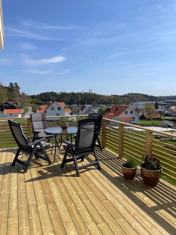 a wooden deck with chairs and a table on it at Stuga Tjörn/Almösund in Almösund