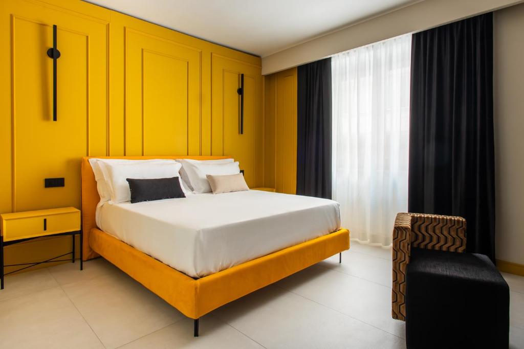 una camera con un letto e una parete gialla di Welmy Napoli a Napoli