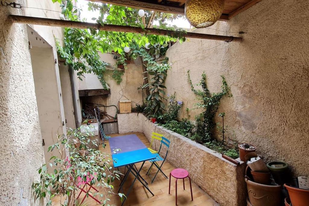 un patio avec une table, des chaises et des plantes dans l'établissement Agréable maison de ville avec patio, à Marseille