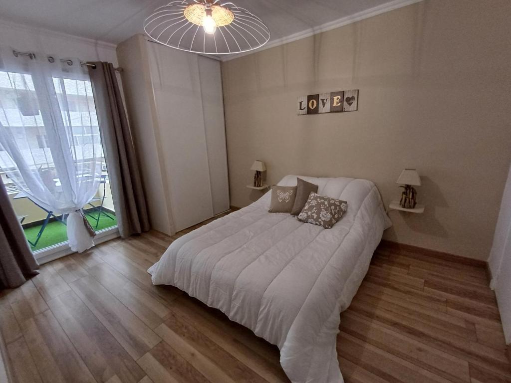 a bedroom with a large bed and a large window at Le Sud, pdcompri in Toulon