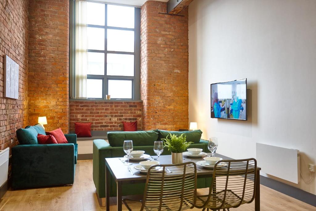 un soggiorno con un divano e un tavolo di The Ruby Suite a Manchester