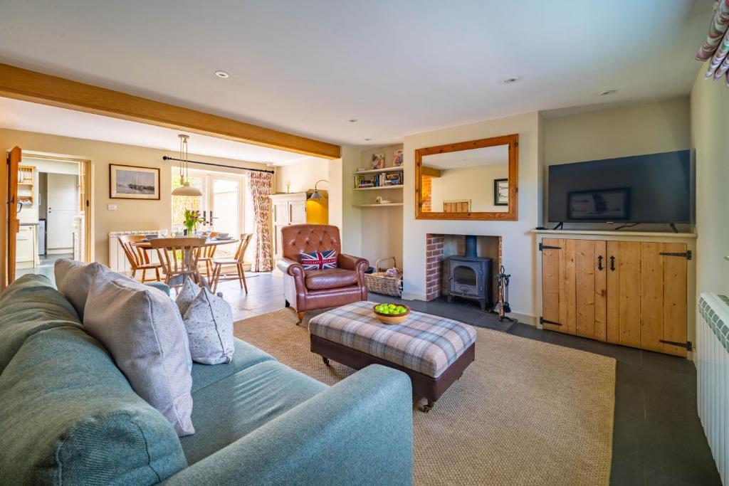 a living room with a couch and a table at Goose Cottage by Big Skies Cottages in Titchwell