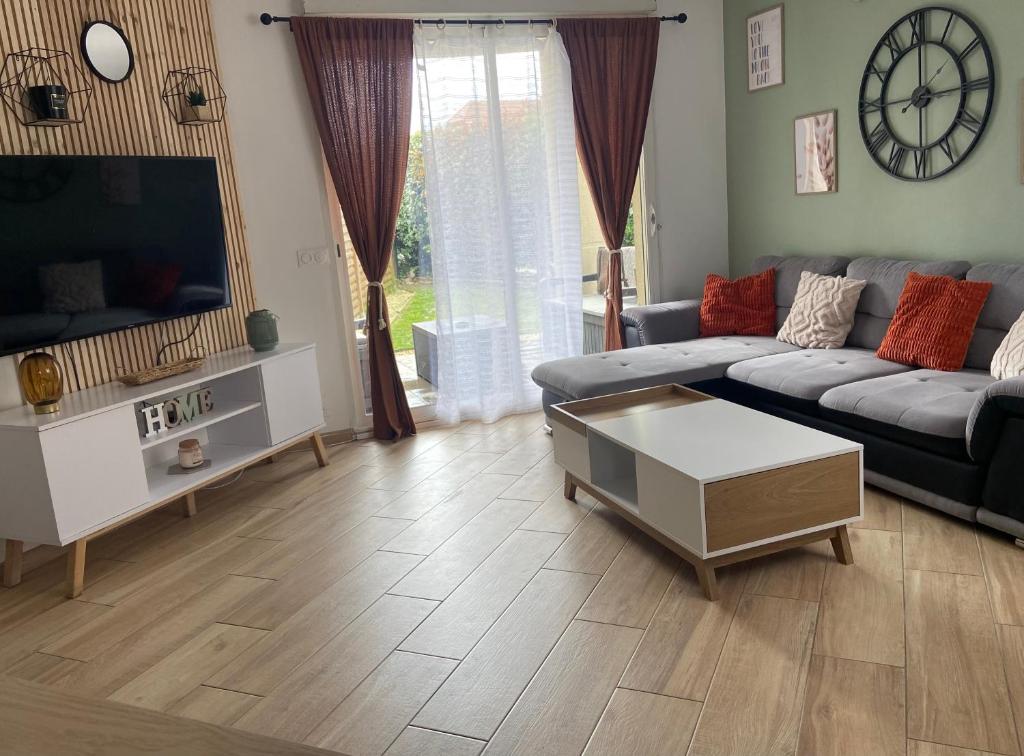 un salon avec un canapé et une télévision dans l'établissement T2 cosy 4 places RDC - jardin, à Lons